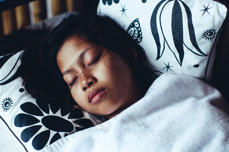 Young Asian woman sleeping peacefully in the bacony during summer vacationの写真素材