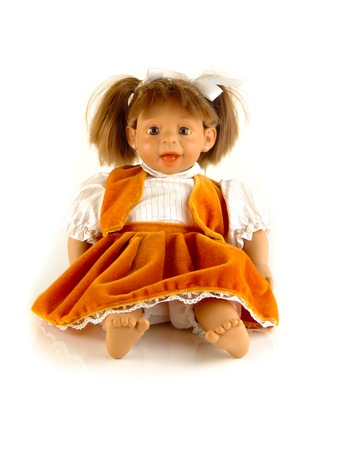 Cute little plastic baby doll with blue eyes sitting on empty backgroundの写真素材