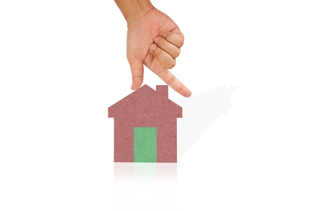 Hand hold house created from color paper with shadow and reflectionの写真素材