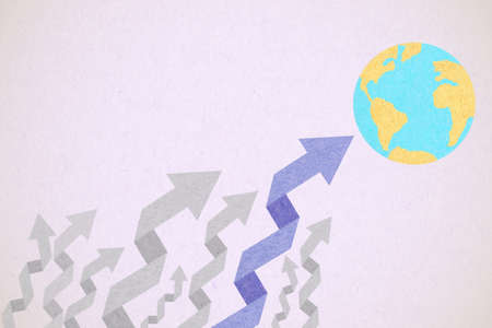Arrow pointing the world created from textured paper style の写真素材