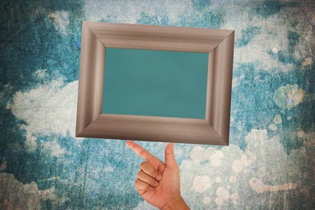 Hand hold blank wood frame on grunge background