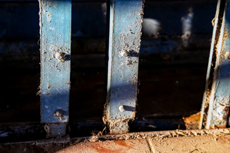 Close up of a rusty metal fence with peeling blue paint.の写真素材