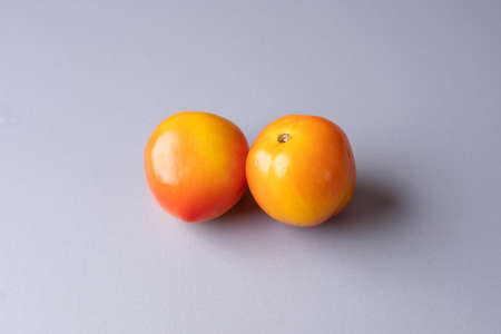 two tomatoes on top of a tableの写真素材