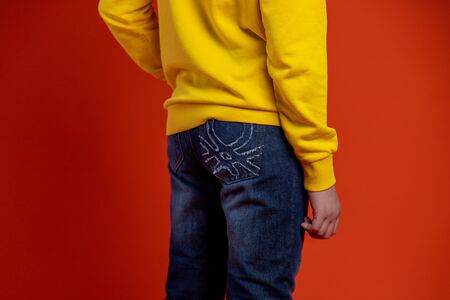 Satisfied male model points at blank space of his yellow t shirt, shows mockup place for slogan, advertisement or brand label, focused down, advertises clothes, likes yellow color, isolated.の写真素材