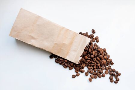 coffee in a paper bag. coffee beans in a paper bag. high-class coffee spilled out of the bag.の写真素材