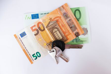 money and keys on a white background. euros and house keys. home purchase, mortgageの写真素材