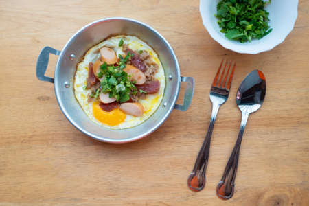 Breakfast, eggs, pans on a wooden tableの写真素材