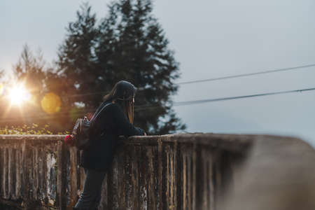 The young woman in black shirt is standing thinkingの写真素材