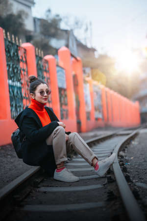 A girl sitting on the train tracksの写真素材