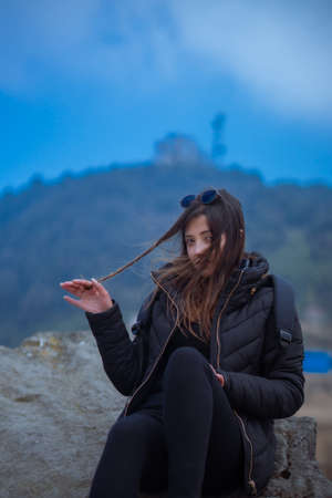 Girl sitting on a rock on a cliffの写真素材
