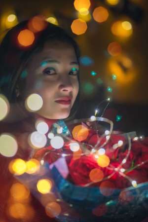 Girl with a bouquet of roses and bokeh lights On valentines dayの写真素材