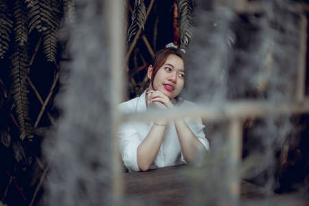 Girl sitting in a chair green tree backgroundの写真素材