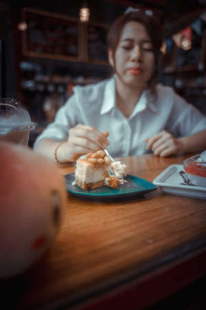Young female student eating cake in a coffee shop
