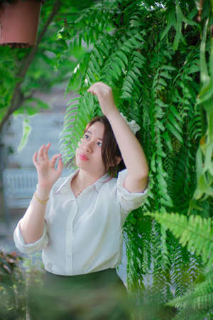 Girl sitting in a chair green tree background