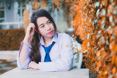 Girl sitting in a chair green tree backgroundの写真素材