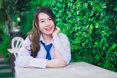 Girl sitting in a chair green tree backgroundの写真素材