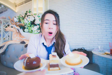 Young female student eating cake in a coffee shop