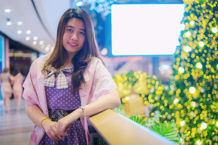 Beautiful girl with Christmas tree and bokehの写真素材