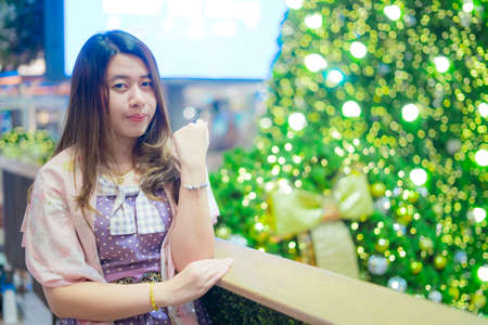 Beautiful girl with Christmas tree and bokehの写真素材