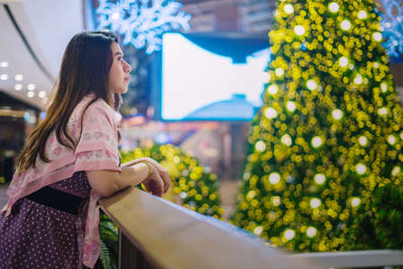 Beautiful girl with Christmas tree and bokehの写真素材