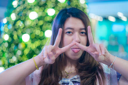 Beautiful girl with Christmas tree and bokeh