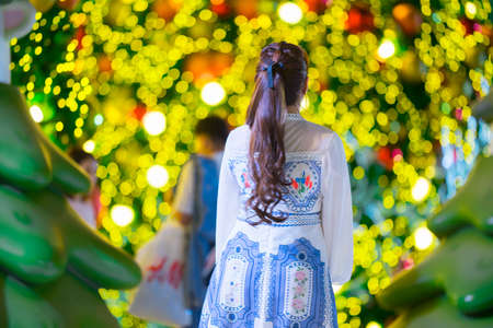 Beautiful girl with Christmas tree and bokehの写真素材