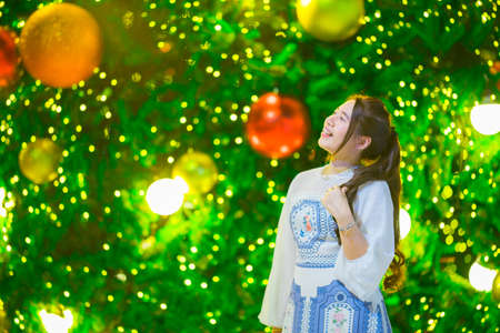 Beautiful girl with Christmas tree and bokeh