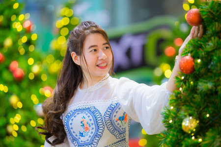 Beautiful girl with Christmas tree and bokehの写真素材