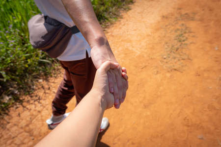 Young lovers couple holding hands in the forest.の写真素材