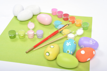 Colorful paints and brushes for art project with your child - coloring wooden eggs with fun bright patternsの写真素材