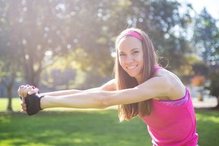 Young attractive woman working out in summer park