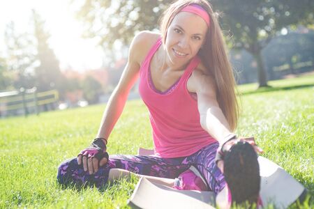Young attractive woman working out in summer park