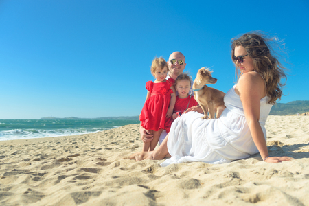 Family with kids and dog on the beachの写真素材
