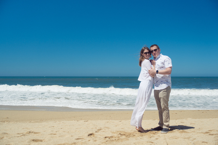 Young romantic couple hugging on the beachの写真素材