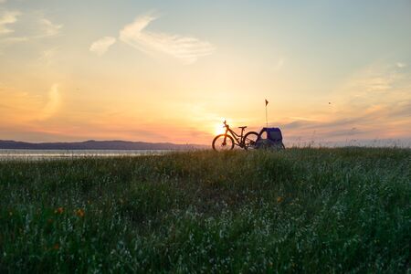 Biking in the hills at sunset with child trailerの写真素材