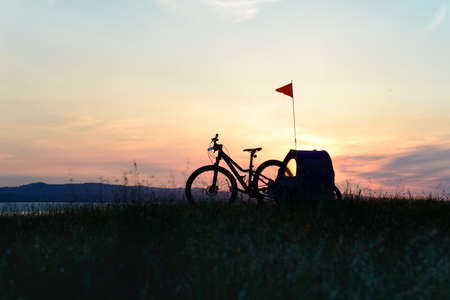 Biking in the hills at sunset with child trailerの写真素材