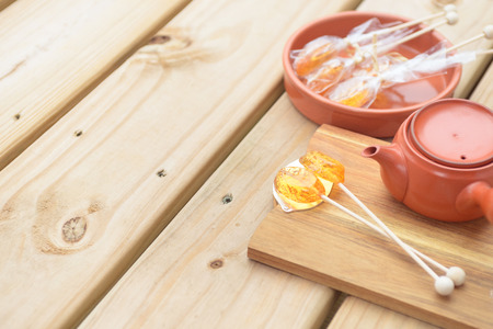 Candy lollipop and teapot on wooden backgroundの写真素材