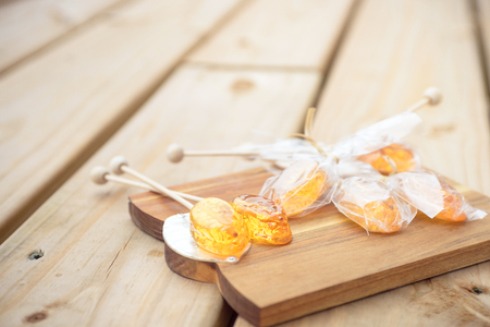 Honey caramel candy lollipop on wooden backgroundの写真素材