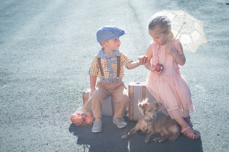 Small boy sharing apple with girl in vintage dressの写真素材