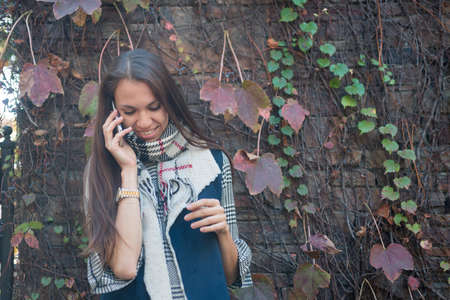 Smiling woman talking on her phone outsideの写真素材