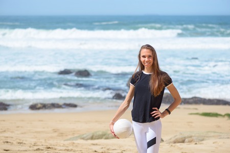 Active young woman on the beach with volleyball ballの写真素材