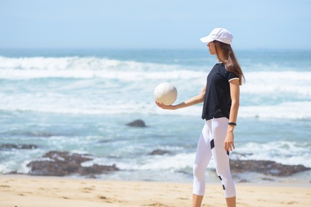 Active young woman on the beach with volleyball ballの写真素材