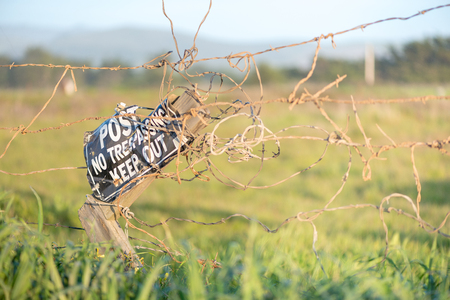 Close up of barbed wire fence with no trespassing sign on private ranchの写真素材