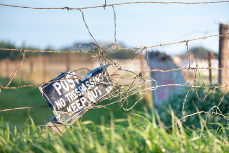 Close up of barbed wire fence with no trespassing sign on private ranchの写真素材