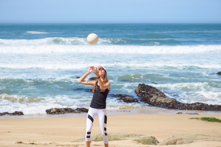 Active young woman on the beach with volleyball ballの写真素材