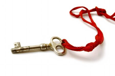 Old Key on a white background with red stringの写真素材