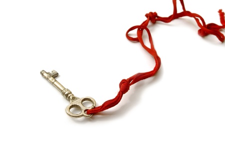 Old Key on a white background with red stringの写真素材