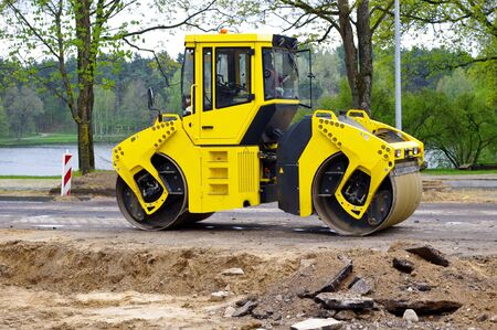 Yellow road roller on asphalt 