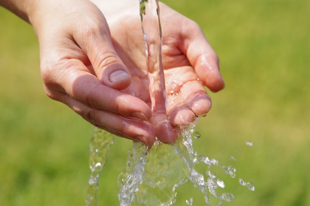 Woman's hands with water splash の写真素材