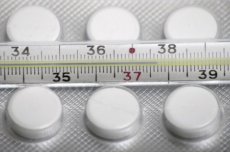 Close-up medical thermometer and pills